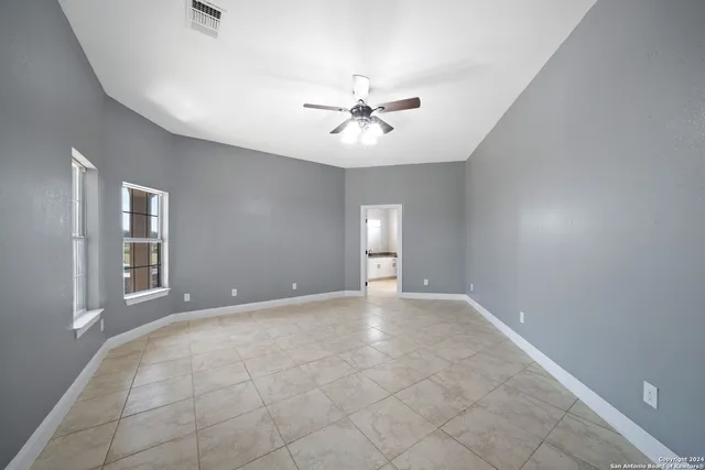 an empty room with fan and ceiling fan