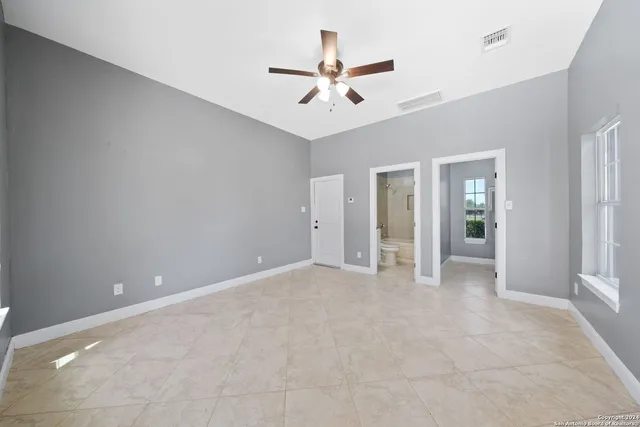 a view of an empty room with a window and cabinet