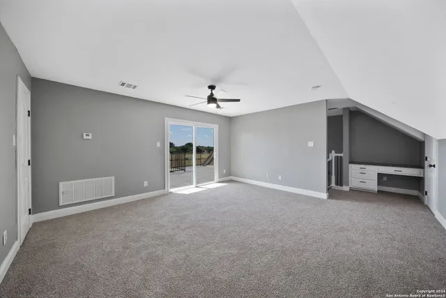 a view of an empty room with a ceiling fan