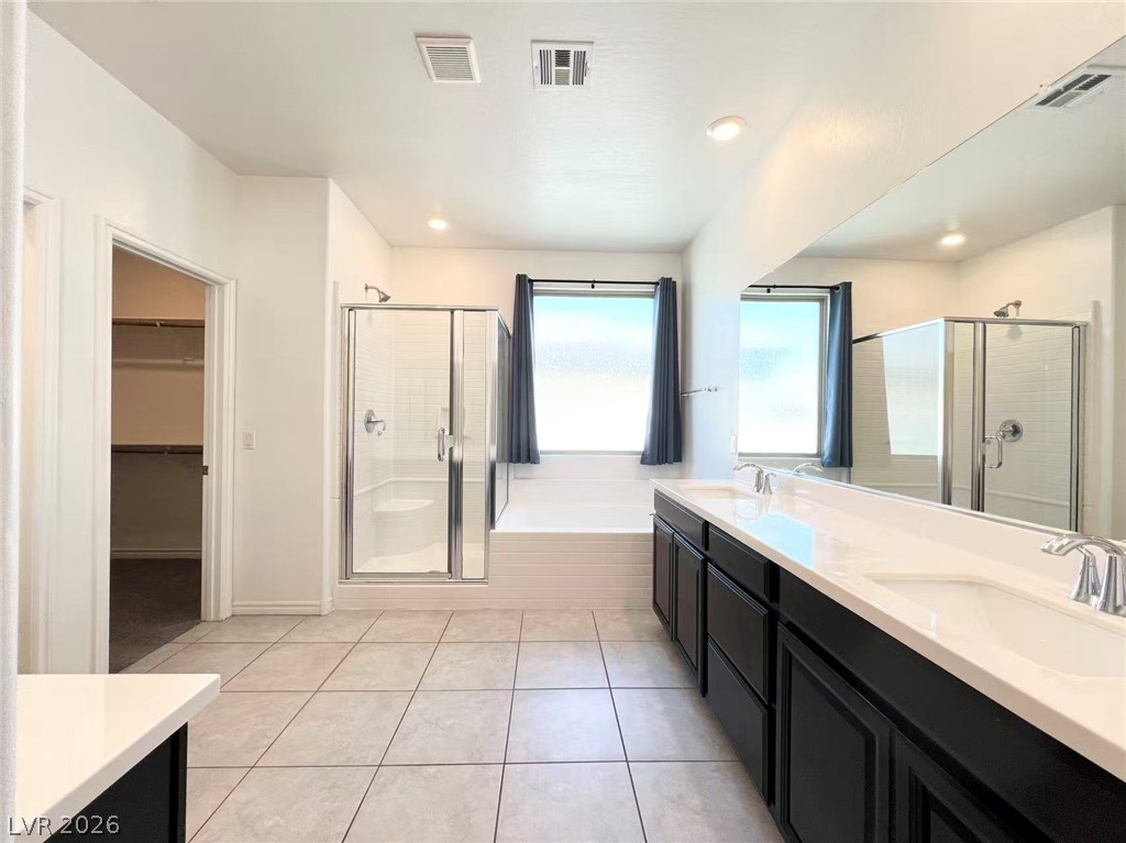925 Bayberry Ridge Street Henderson, NV 89052 - Photo 16 of 27 Dual vanities and a spacious shower elevate daily routines in this well-appointed bathroom.