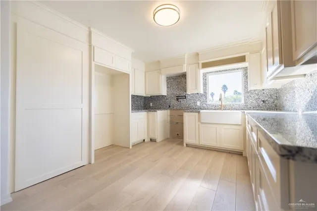 a kitchen with a sink a window stainless steel appliances and cabinets