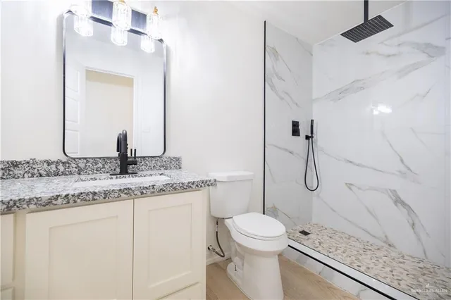 a bathroom with a granite countertop sink toilet and shower