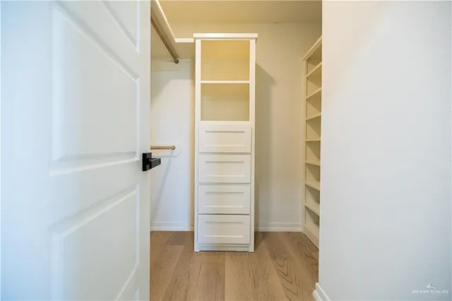 a view of walk in closet with empty racks