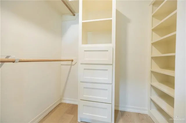 a view of walk in closet with empty racks