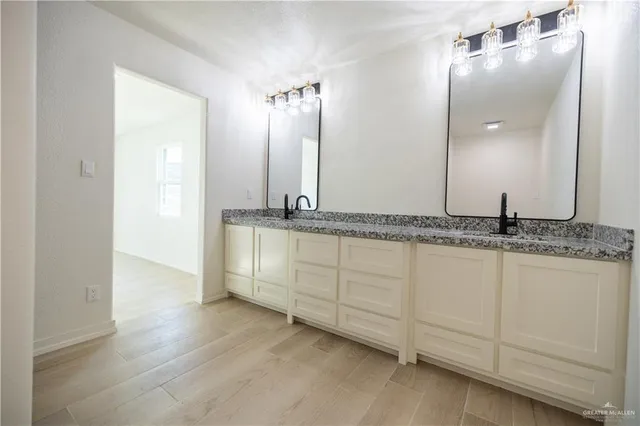 a spacious bathroom with a granite countertop sink and a mirror