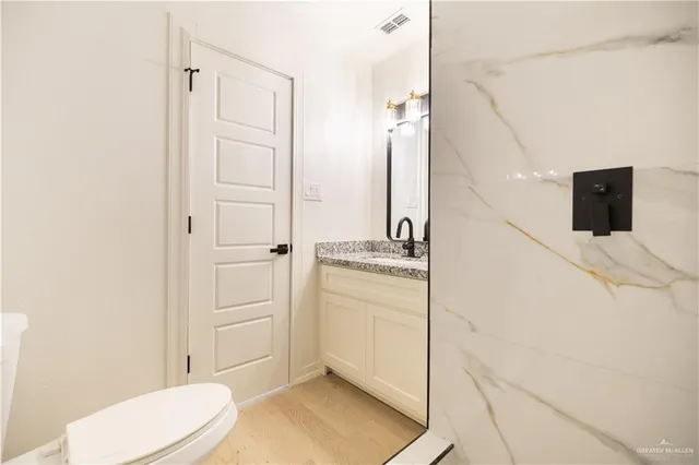 a bathroom with a toilet a sink and mirror