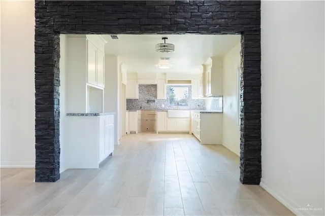 a view of a kitchen with a window and wooden floor