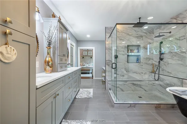 a bathroom with a double vanity sink mirror and shower