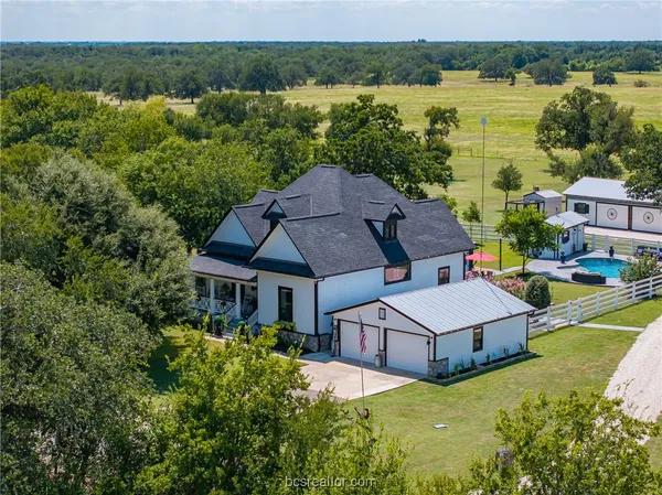 an aerial view of a house with pool lake view and mountain view