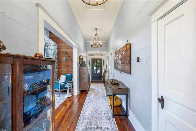 a hallway with wooden floor and furniture