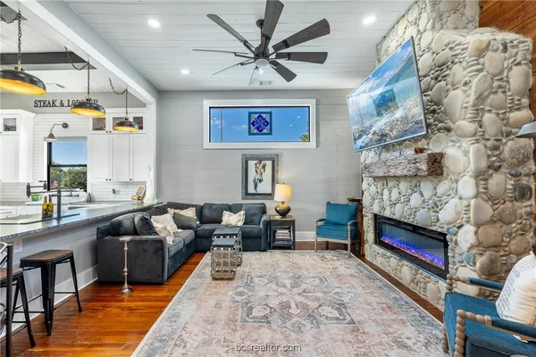 a living room with stainless steel appliances kitchen island granite countertop furniture and a couch