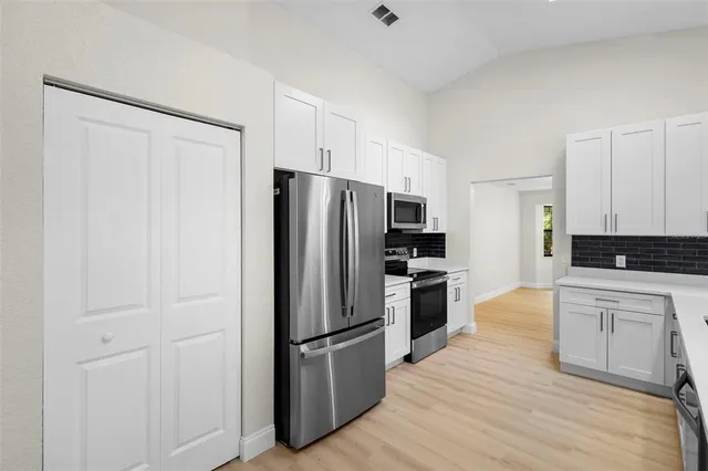 a kitchen with a refrigerator a stove top oven a sink and cabinets