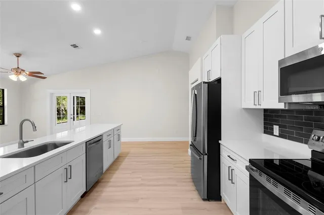 a kitchen with stainless steel appliances a sink stove and refrigerator
