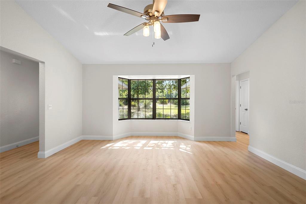 26 Laurianne Road DeBary, FL 32713 - Photo 15 of 41 an empty room with wooden floor chandelier fan and windows