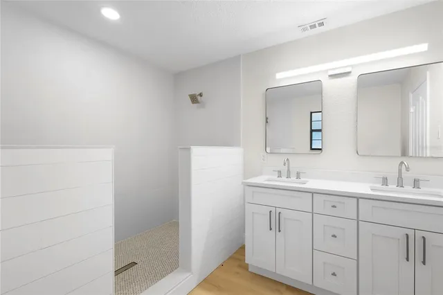 a bathroom with a double vanity sink and mirror