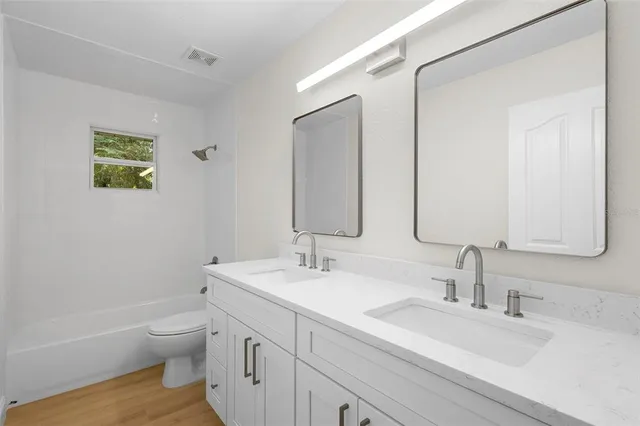 a bathroom with a sink a toilet and a large mirror