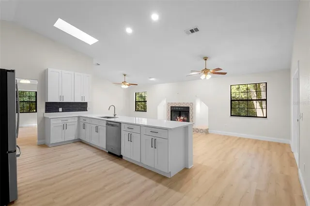 a large kitchen with stainless steel appliances granite countertop a large center island and a wooden floors