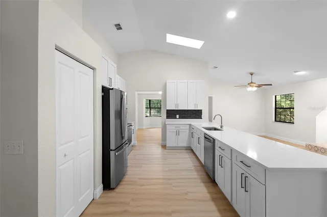 a kitchen with white cabinets and stainless steel appliances