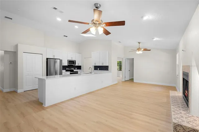 a view of kitchen with stainless steel appliances refrigerator stove microwave and cabinets