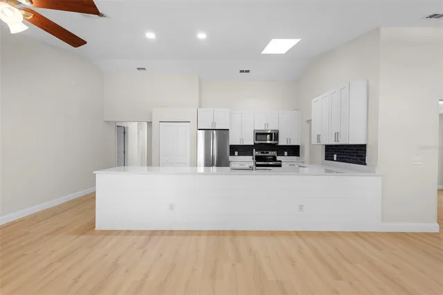a view of kitchen with stainless steel appliances cabinets