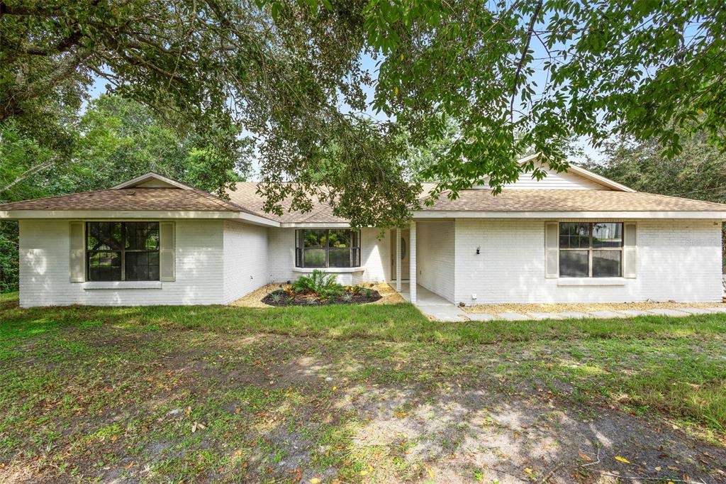26 Laurianne Road DeBary, FL 32713 - Photo 4 of 41 a front view of a house with a garden and trees