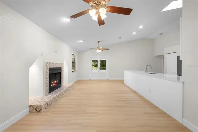 a view of an empty room with a fireplace and a window