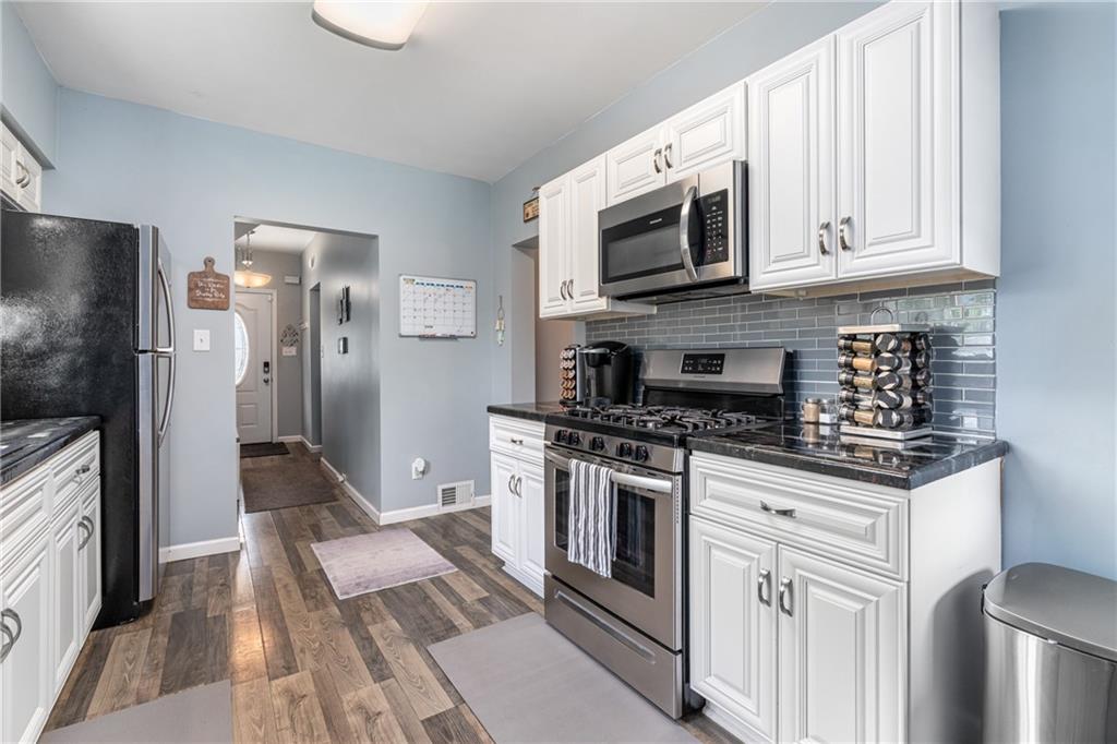 334 Orchard Street Springdale, PA 15144 - Photo 12 of 25 a kitchen with stainless steel appliances granite countertop a stove a refrigerator and a microwave