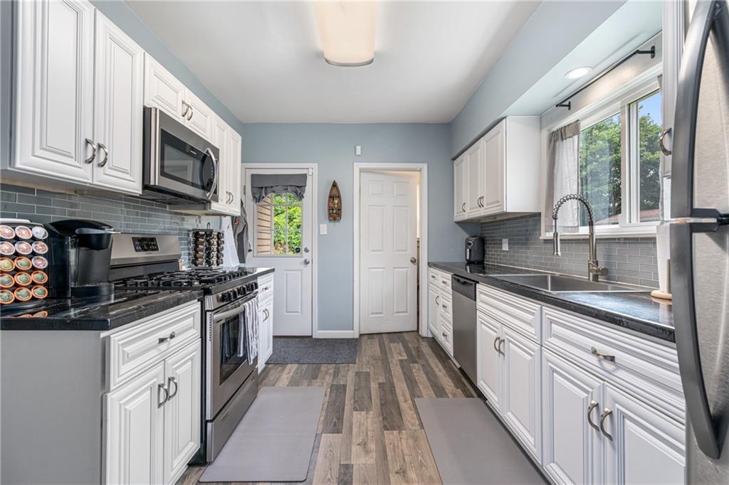 334 Orchard Street Springdale, PA 15144 - Photo 10 of 25 a kitchen with stainless steel appliances granite countertop a stove and a sink