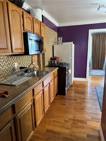 a kitchen with stainless steel appliances granite countertop a sink stove and wooden cabinets