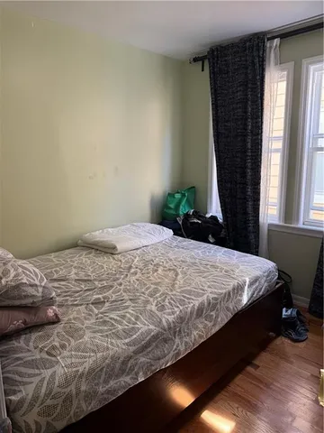 a bed sitting in a bedroom next to a window