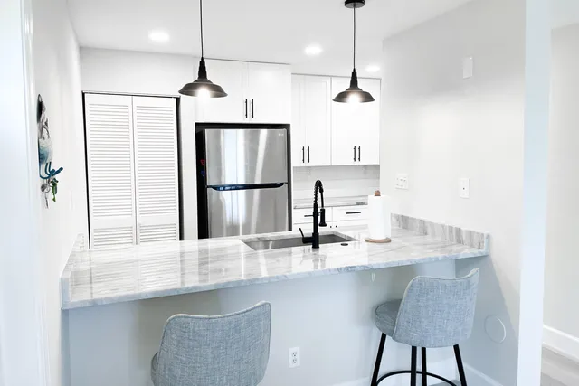 a kitchen with stainless steel appliances granite countertop a sink refrigerator and microwave