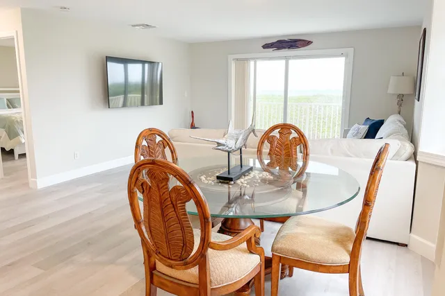 a dining room with furniture window and wooden floor