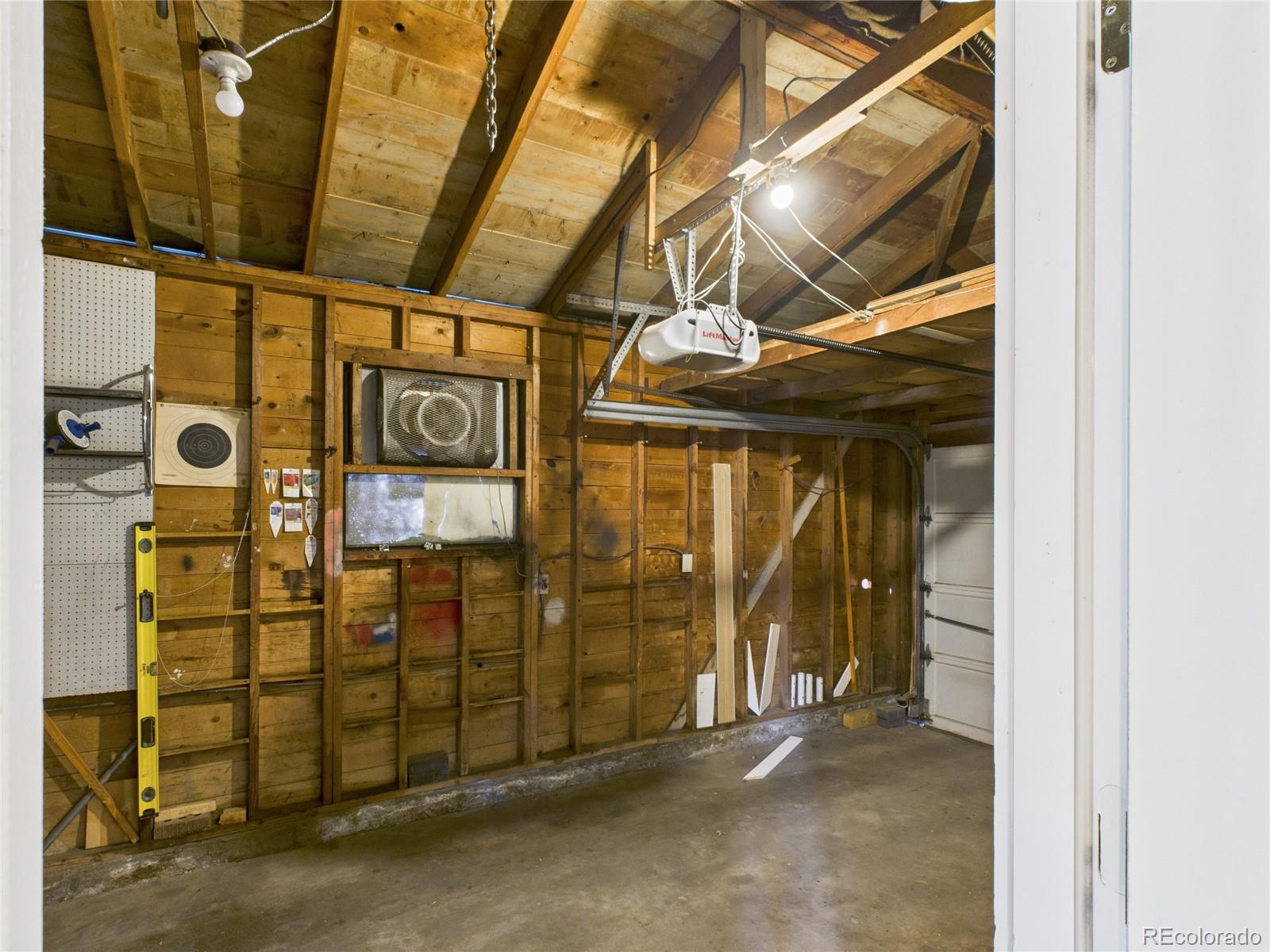 1360 South Ivy Way Denver, CO 80224 - Photo 18 of 23 a view of a garage with wooden wall