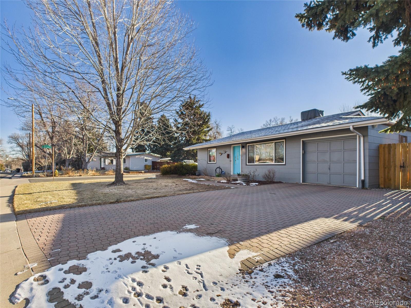 1360 South Ivy Way Denver, CO 80224 - Photo 2 of 23 a front view of a house with a yard and trees