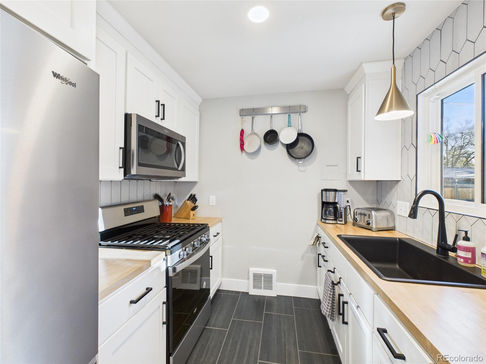 1360 South Ivy Way Denver, CO 80224 - Photo 7 of 23 a kitchen that has a sink and a stove top oven