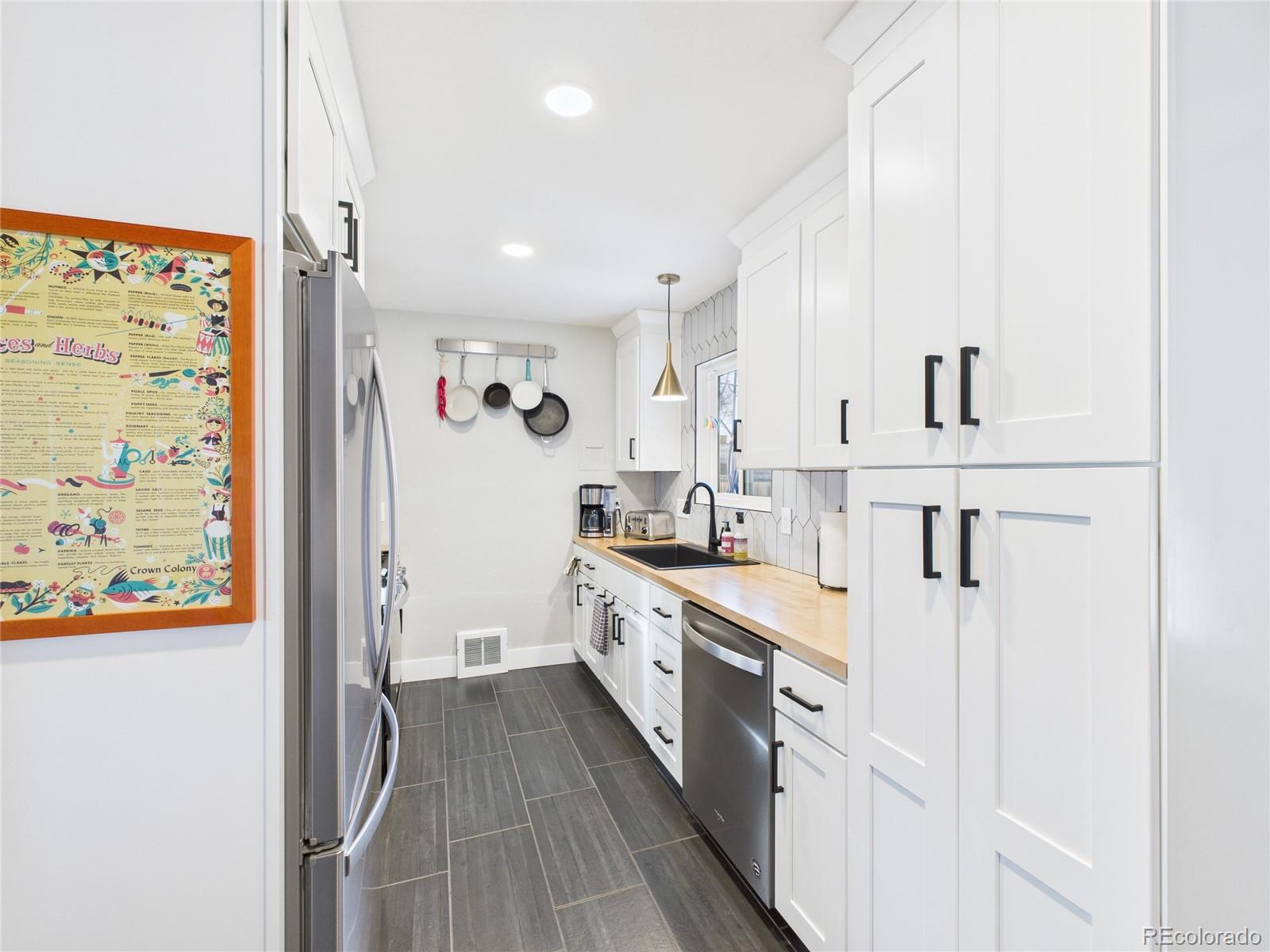 1360 South Ivy Way Denver, CO 80224 - Photo 8 of 23 a large white kitchen with stainless steel appliances