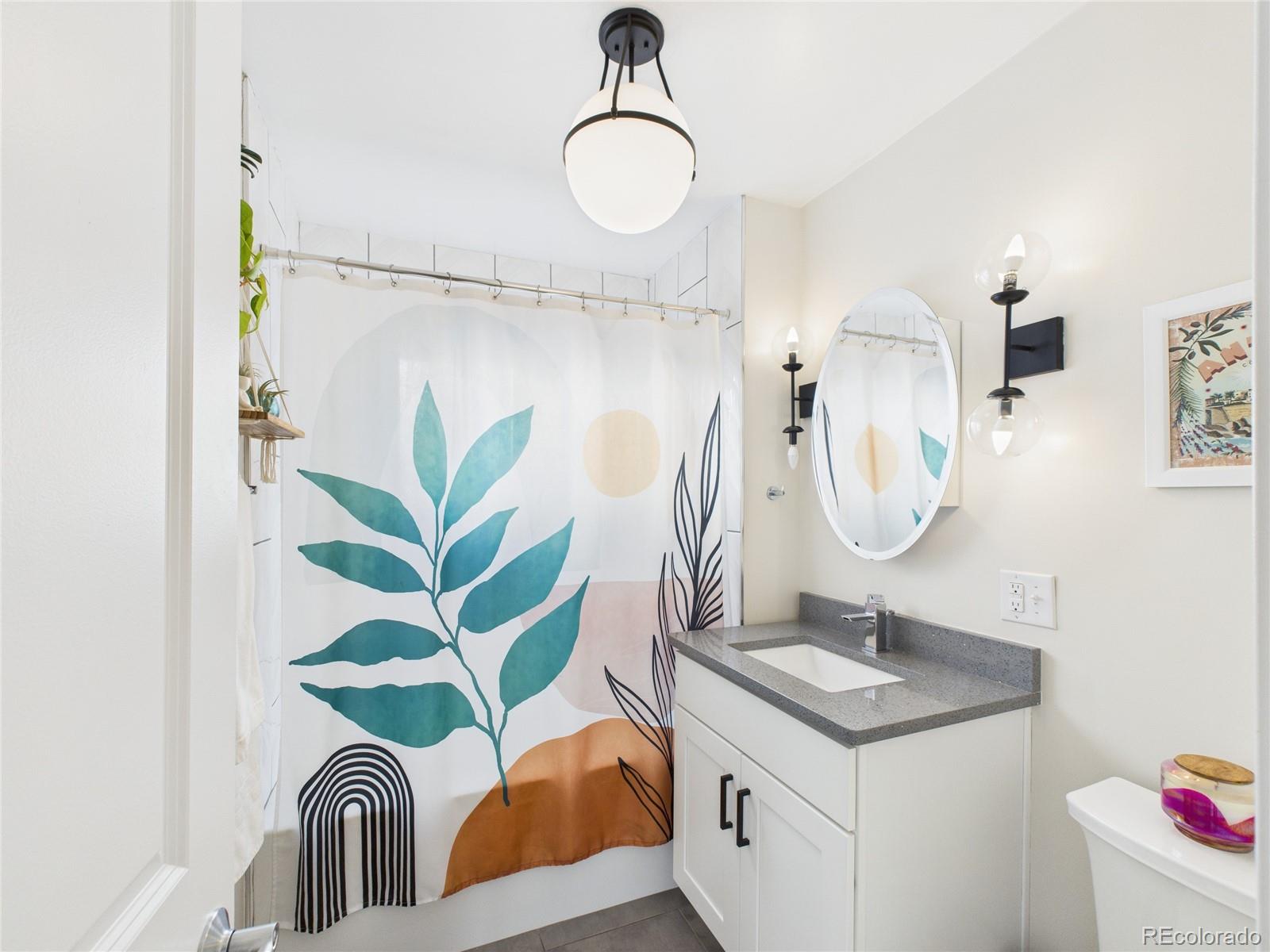 1360 South Ivy Way Denver, CO 80224 - Photo 9 of 23 a bathroom with a sink a mirror and a shower curtain