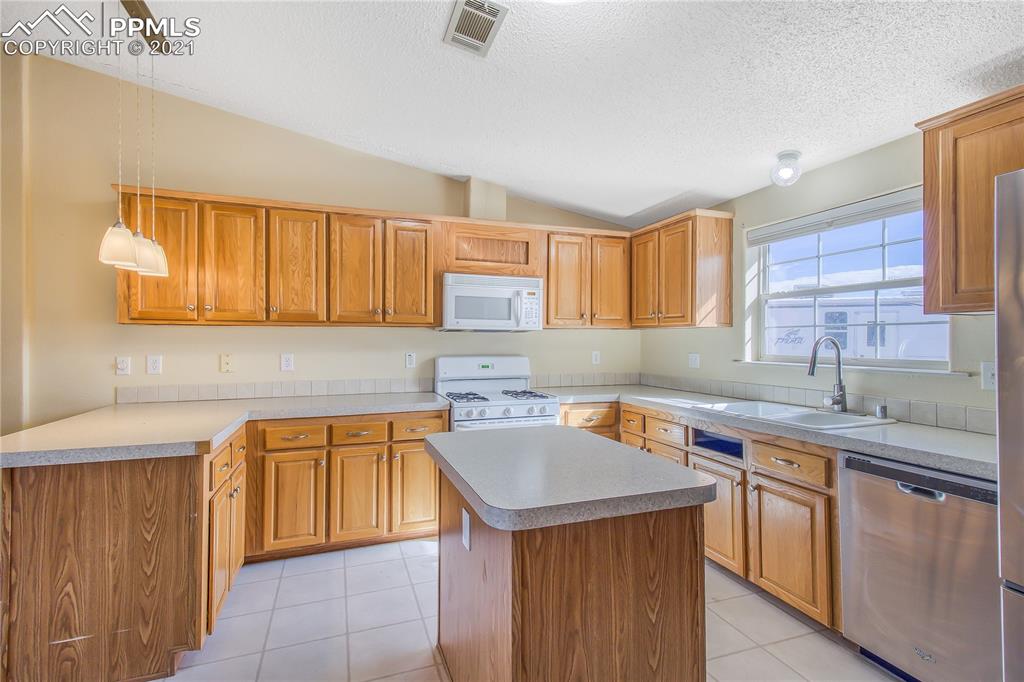 4765 South Johnson Road Rush, CO 80833 - Photo 22 of 41 a kitchen with a sink a stove cabinets and a window