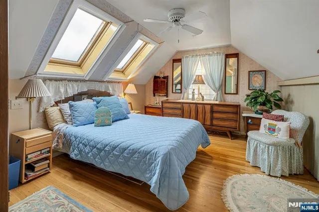 a spacious bedroom with a bed and wooden floor