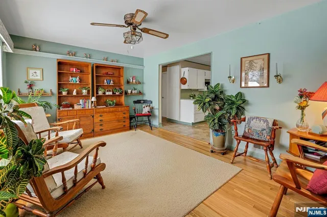 a living room with furniture a chandelier and a potted plant