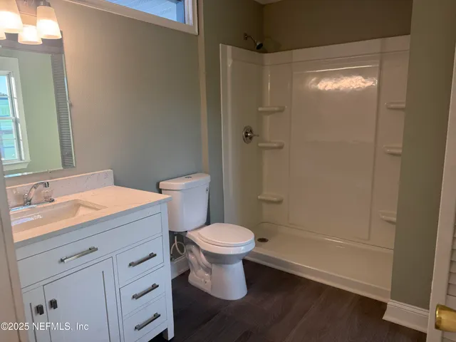 a bathroom with a sink a toilet and shower