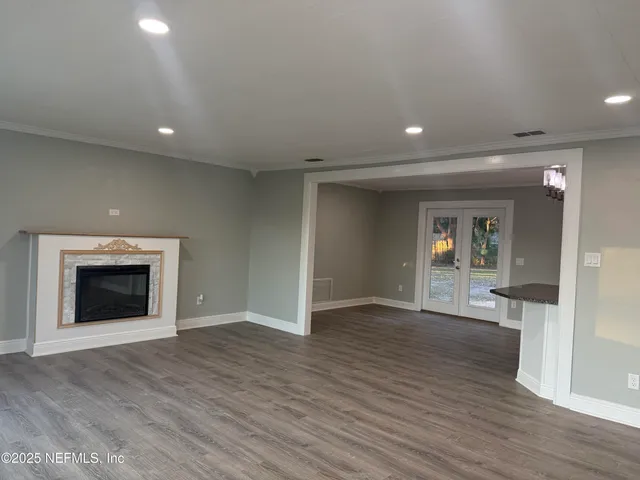 an empty room with wooden floor and a fireplace
