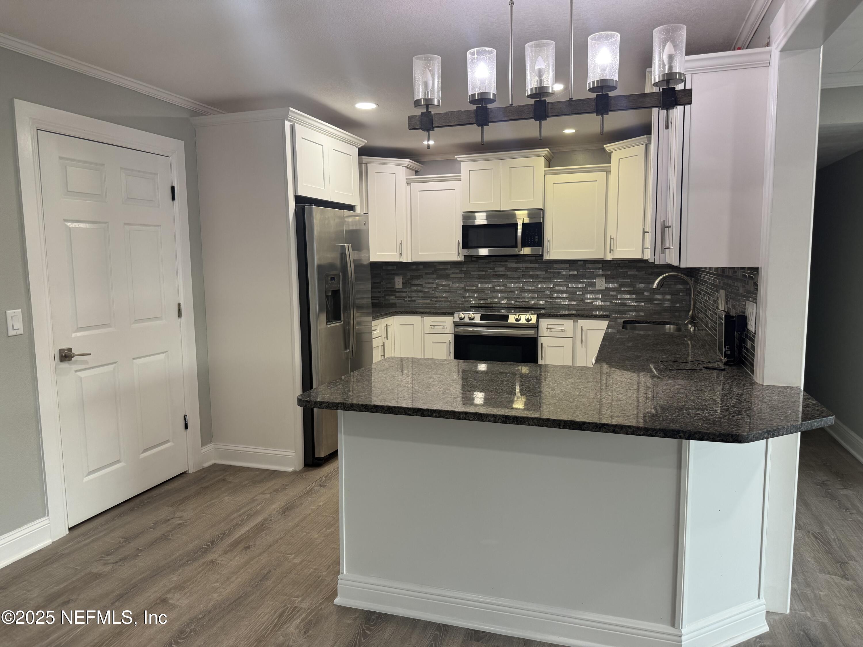 4901 Cedar Point Road Jacksonville, FL 32226 - Photo 7 of 15 a kitchen with stainless steel appliances granite countertop a sink and a refrigerator