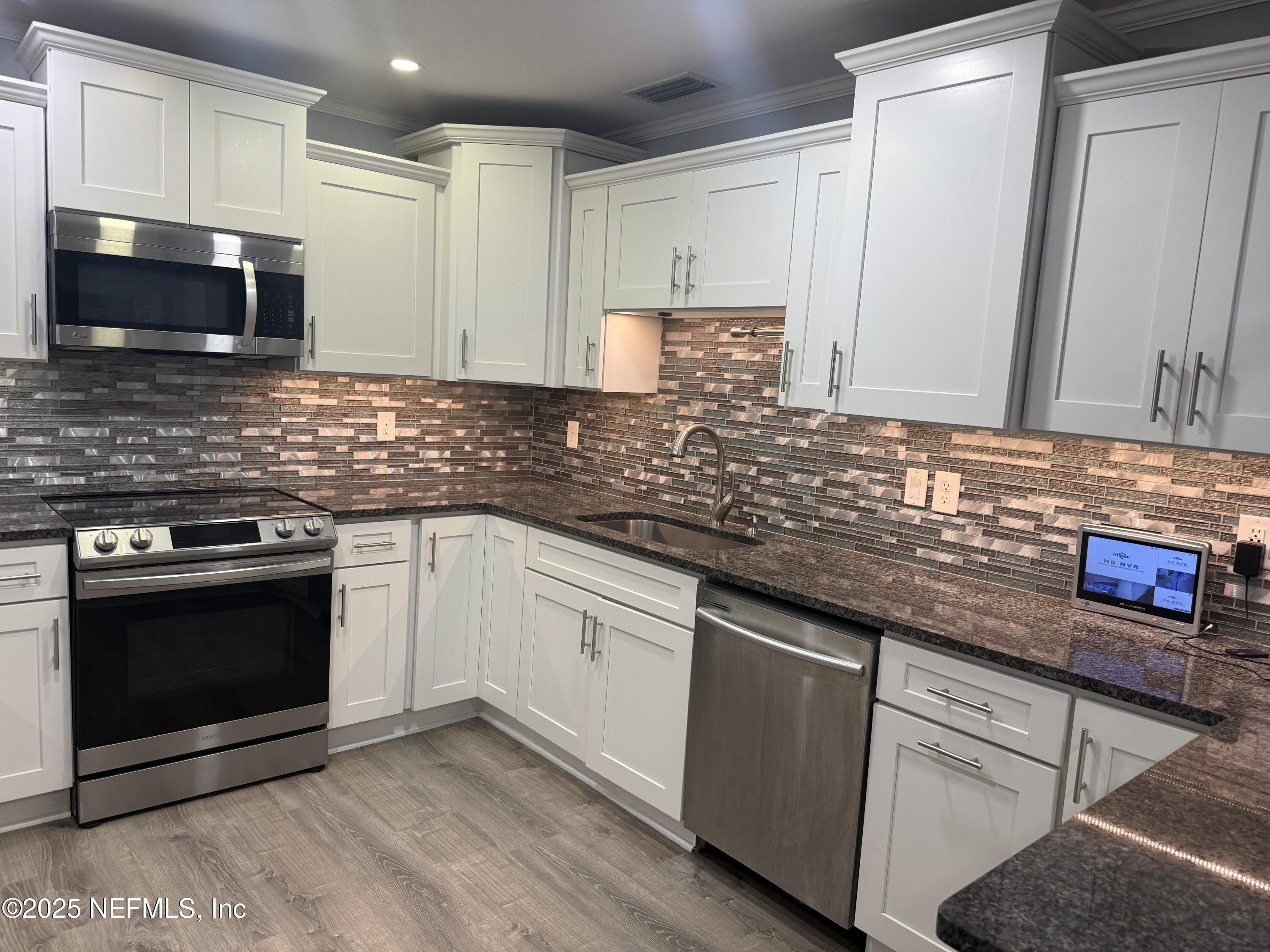 4901 Cedar Point Road Jacksonville, FL 32226 - Photo 8 of 15 a kitchen with granite countertop a sink stove and microwave