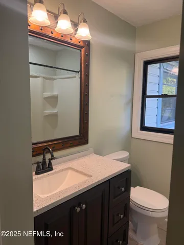 a bathroom with a sink a toilet and mirror
