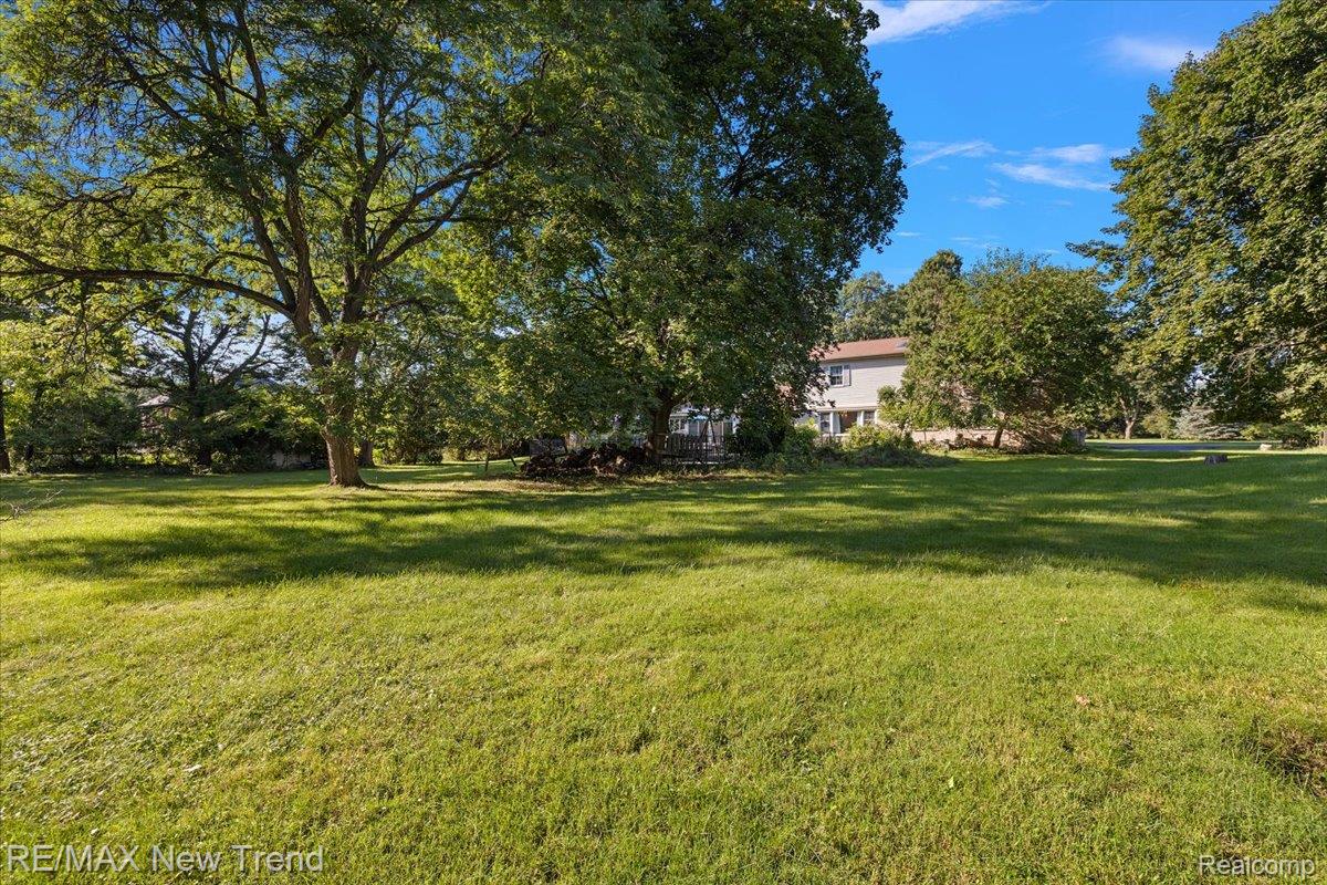 1450 Lenox Road Bloomfield Hills, MI 48304 - Photo 71 of 79 Expansive lawn with mature trees and a distant two-story residence