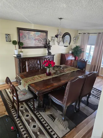 a kitchen with stainless steel appliances kitchen island granite countertop a table chairs sink and cabinets