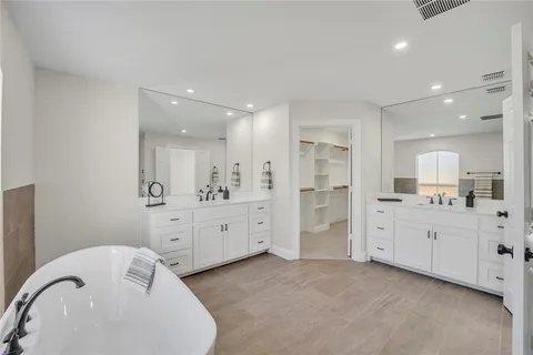 a large white bathroom with a granite countertop sink mirror and a bathtub