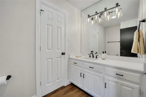 a bathroom with a double vanity sink a mirror and a bathtub