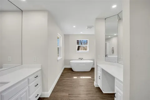 a large bathroom with a tub sink shower and mirror